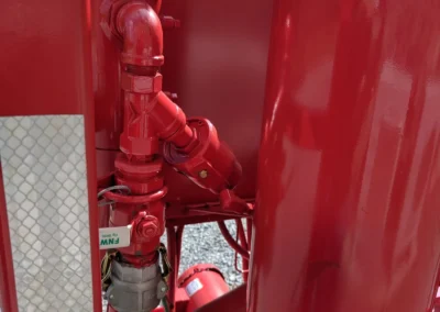 Rear view of a vacuum dehydrator rental unit showing utility connections, pump housing, and structural frame